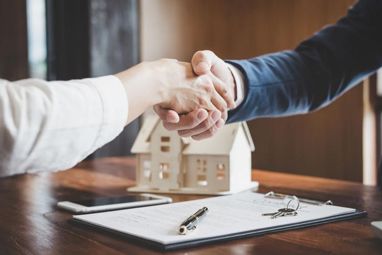 房地产经纪人和客户握手庆祝完成合同后-关于住房保险和投资贷款-握手